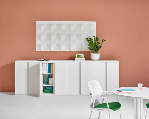 geometric panel wall art in pink room with white office furniture