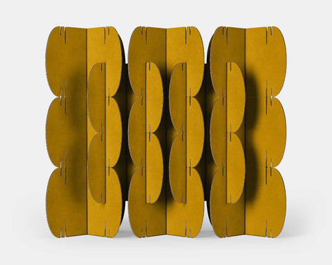 Nomad System room divider with 26 ochre-colored cardboard modules arranged in an artistic spatial partition