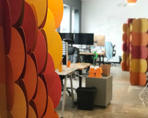Nomad System room dividers in warm colors installed in an office setting for visual interest and spatial organization