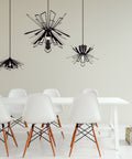 Three Black Bendant lamps over a dining table with sic chairs