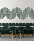 Modern interior design with green upholstered chairs and decorative wall panels.