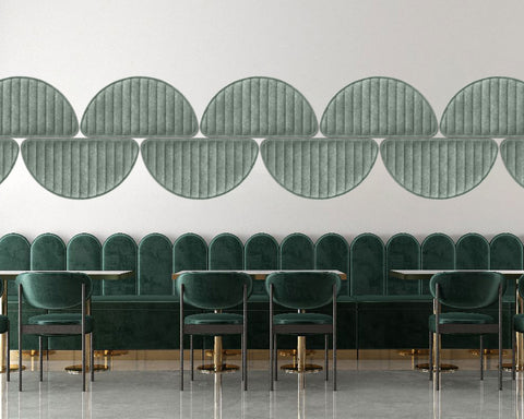 Modern interior design with green upholstered chairs and decorative wall panels.