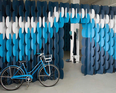 Nomad System room divider with elegant wave pattern creating a modern partition wall for versatile space division
