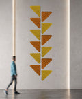 triangular wall art quilts in orange and mustard in hallway