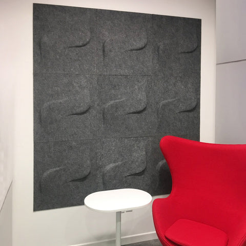 Twist FeltForms 2' x 2' Acoustic wall tile in mottled grey inside a phone booth with comfy red chair and side table.